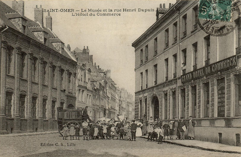 Une vue très animée où l'on peut apercevoir une voiture à cheval qui amenait sûrement des voyageurs à l'Hôtel du Commerce situé à droite. 